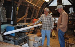 Ted Tavares and Alan Lunn working on the new flagpole in the Boat Shop. Photo by Susan F. Witzell